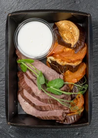 Baked eggplant with tomatoes, veal roast beef, and yogurt sauce